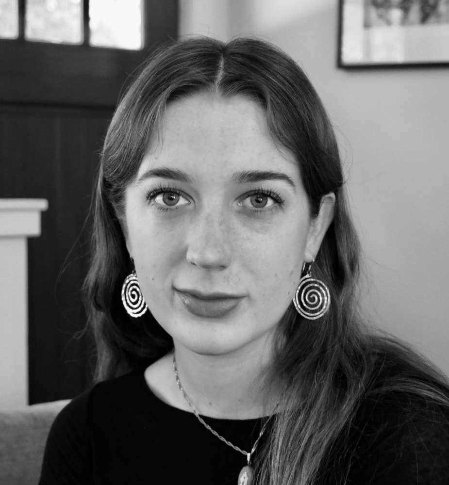 A black-and-white photo of a young woman wearing earrings